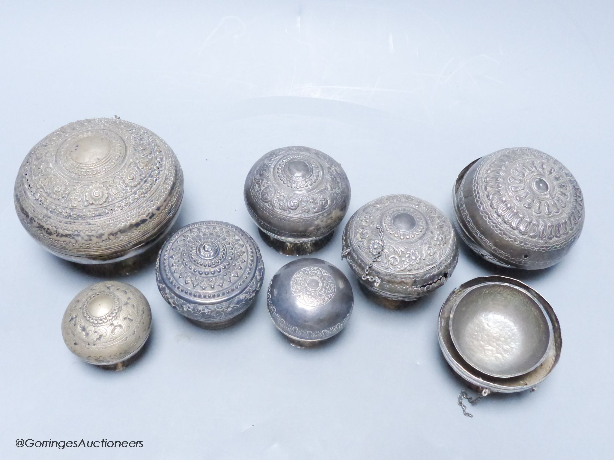 A collection of Malay Straits white metal circular betel nut boxes ('Chimbul'), Diameter 5cm to 10cm